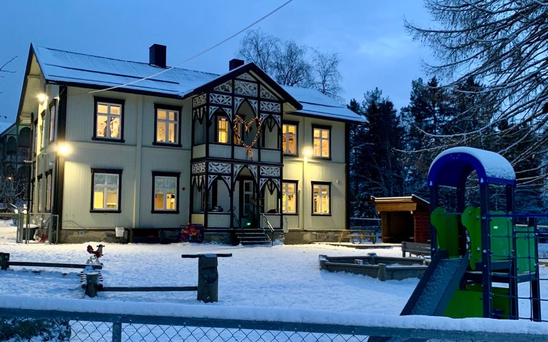 Skolebygning og lekeplass i vintervær